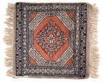TAPETE ORIENTAL, confeccionado em lã, com composição geométrica e medalhão central, em tons de terracota, azul-marinho, bege e marrom. Apresenta franjas nas extremidades. Desgaste do tempo. Ideal para compor mesa de canto. Medidas: 45 x 38 cm.