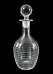 Licoreira em demi cristal translúcido, de corpo arredondado, decorada com frisos horizontais e tampa esférica. Mede 28 cm de altura.