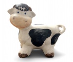 Vaca decorativa, em cerâmica, com pintura policromada nas cores branco, preto e marrom, de estilo lúdico e vintage. Apresenta sinais de uso e desgaste compatíveis com a idade. Mede 20 x 17 cm.