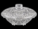 Bomboniere em Demi cristal translúcido, com tampa e pegador facetado, ricamente trabalhada com lapidações geométricas e motivos florais e vegetais em relevo. Peça de elegante efeito decorativo, com corpo e tampa de desenho harmonioso, destacando-se pela riqueza dos detalhes e pelo brilho. Medida: 18 cm de diâmetro.