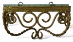 PEANHA em metal dourado, de desenho ornamental com volutas e elementos sinuosos, apresentando tampo em vidro translúcido e ferragens para fixação à parede. Décor de inspiração francesa, estilo Luís XV. Mede 11cm x 15cm x 10cm.