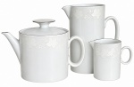 Conjunto de chá em porcelana branca, composto por bule com tampa, leiteira e jarra, decorado com delicado motivo floral em relevo e filetes prateados. Elegante e em bom estado de conservação. Possui registro da manufatura na base. Medida do maior: 17 x 15 cm.