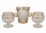 ANOS 50 - Conjunto de peças em cristal, anos 1950, com decoração em faixas douradas e acabamento translúcido, de elegante estética vintage. Composto por porta gelo com altas e duas taças. Desgaste do tempo. Medida da maior: 18 x 15 cm.