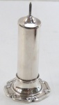 Paliteiro em metal espessurado à prata, corpo cilíndrico, decoração laço de fita, base redonda. Med. 16 cm altura.