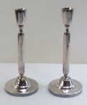 BRISTOL- Par de castiçais em metal espessurado a prata, coluna cilíndrica, base redonda. Med. 23 cm altura.
