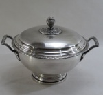 WOLFF - Uma (1) sopeira em metal espessurado à prata padrão laço de fita, em formato côncavo, alças vazadas e modeladas em folhas, pega da tampa em forma de fruto, ornamentada. Medidas 32x25 cm. Tampa necessita prateação.