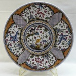 ESTRELA DE CONIMBRIGA Séc XVII  -  Grande e exuberante medalhão em faiança portuguesa,decorado com animais, pássaros, florais e guirlandas em farta policromia. Med. 4 x 43,5 cm.