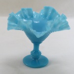 Uveira em opalina na cor azul turquesa, base redonda, haste cabochard, corpo bico de jaca, borda movimentada em babados feito a mão, possivelmente francesa. Med. 14 x 17 cm.