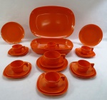 GOYANA MELCROME - década de 70-  Conjunto em plástico melamina, na cor laranja, composto de vinte e quatro (24) peças, travessa ovalada ( 36 x 15 cm), travessa funda ( 6 x 29 x 20 cm), seis pratos de bolo ( 18 cm diâmetro), seis xícaras de café com pires e uma xícara de chá com seis pires.