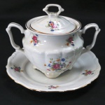 C.T. TIELSCH WALBRZYCH. POLAND - Açucareiro com pratinho em porcelana branca vitrificada, moldada na pasta, com pintura de flores e folhagens em policromia., frisos dourados Med.:prato 17,5 , açucareiro 13 cm alt.