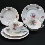 C.T. TIELSCH WALBRZYCH. POLAND - Par de trios em porcelana branca vitrificada, moldada na pasta, com pintura de flores e folhagens em policromia., frisos dourados Meds: prato para bolo 17,5 cm, xícara 5 x 10 cm, pires 14,5 cm.
