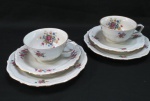 C.T. TIELSCH WALBRZYCH. POLAND - Par de trios em porcelana branca vitrificada, moldada na pasta, com pintura de flores e folhagens em policromia., frisos dourados Meds: prato para bolo 17,5 cm, xícara 5 x 10 cm, pires 14,5 cm.