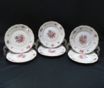 KPM MADE IN POLAND- Seis (06) pratos sobremesa em porcelana polonesa, manufatura KPM. moldada na pasta em guirlandas borda com rosáceas e friso dourado. Med. 19 cm diâmetro.