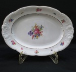 KPM MADE IN POLAND- Grande Travessa oval em porcelana polonesa, manufatura KPM. moldada na pasta em guirlandas borda com rosáceas e friso dourado. Med. 38 x 27 cm.