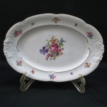 KPM MADE IN POLAND- Travessa oval em porcelana polonesa, manufatura KPM. moldada na pasta em guirlandas borda com rosáceas e friso dourado. Med. 33 x 23 cm.