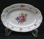 KPM MADE IN POLAND- Travessa oval em porcelana polonesa, manufatura KPM. moldada na pasta em guirlandas borda com rosáceas e friso dourado. Med. 28 x 20 cm.