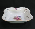 KPM MADE IN POLAND- Uma fruteira quadrangular em porcelana polonesa, manufatura KPM. moldada na pasta em guirlandas borda com rosáceas e friso dourado. Med.5,5 x 23 x 23 cm.