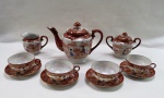 VINTAGE- Aparelho de chá em fina porcelana japonesa esmaltada " Casca de Ovo" decorada no estilo Imari em tom rouge de fer e relevos dourados, com figuras de gueixas, composto; bule de chá ( 18 cm alt), cremeira, açucareiro e  quatro xícaras com pires.