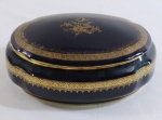 LIMOGES- Grande porta jóia em porcelana francesa na cor azul cobalto, com farta aplicação a ouro, decoração floral. Pequeno desgaste na borda da tampa. Med. 9 x 21 x 15,5 cm.