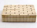 Caixa retangular em madeira, forrada com placas em marfim. Med. 4 x 16 x 11,4 cm.