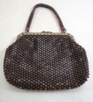 Bolsa toilete dos anos 60, produzida em malha de contas plásticas na cor marrom. Med. 22 x 18 cm.