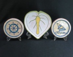 MARCO ANTONIO ZAPPAROLLI  - Três (03) peças decorativas em cerâmica vitrificada, sendo; Dois cinzeiros com motivos nauticos ( 14 cm diâmetro), uma petisqueira no formato de coração ( 20 cm diâmetro). Fabricado no Atelie M. Zappa.