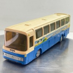 Miniatura colecionável vintage referente ao autocarro de turismo Mercedes-Benz, fabricada pela marca francesa Majorette na escala 1/55. Apresenta pintura bicolor com saia e para-choque em azul-vivo e seção superior/teto em bege-creme. Destaca-se pela temática de turismo "Sun Tours", contando com grafismos e ilustrações nas laterais referentes a praia/férias (guarda-sol e ondas), inclui grelha frontal prateada com a estrela de três pontas da Mercedes-Benz, para-brisas panorâmico em acrílico amarelado, tampa de bagageiro lateral articulada no chassis e rodas plásticas características da Majorette.  Marcas do tempo e de uso.