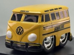 Miniatura die-cast estilizada em formato de caricatura (estilo tooned / hot rod) de uma carrinha Volkswagen T1 (1952 Volkswagen Bus, Jada Toys, modelo NO.96272) caracterizada como autocarro escolar ("School Bus"). Apresenta carroçaria em tom amarelo-dourado com faixas pretas laterais e a inscrição "SCHOOL BUS" nas laterais e acima do para-brisa frontal, logótipo VW proeminente na frente, para-choques pretos, grandes jantes cromadas salientes com pneus largos, e chassi inferior em plástico preto com gravações do fabricante. Medidas: 05 x 08 x 05 cm. Com marcas de tempo de uso.   
