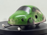 Miniatura brinquedo vintage em chapa/fita de metal litografada na cor verde, representando o Volkswagen Carocha ("VW 1200 Brouk"), fabricada na República Checa pela Kovap (Náchod). Apresenta ilustrações impressas detalhando faróis, vidros, portas e a numeração de corrida "12", mecanismo mecânico de corda (não acompanha a chave lateral), antena/haste frontal metálica de direcionamento dotada de pontas plásticas brancas, rodado inferior funcional e embalagem original ilustrada em cartão ("VW 1200 BROUK - KOVAP NÁCHOD MADE IN CZECH REPUBLIC"). Medidas: 05 x 08x 06 cm. Com marcas de tempo de uso.