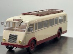 Miniatura die-cast do autocarro clássico Renault 215 D nas cores bege e bordeaux, com destino "TOULON". Apresenta pormenores detalhados, incluindo tejadilho com grade de bagagem e escada de acesso posterior, grelha frontal central com faróis circulares amarelos, para-choques e jantes a condizer, placas de matrícula "380 L.83" e chassi inferior gravado com a identificação "1/43 RENAULT 215 D". Com marcas de tempo de uso.