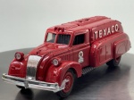Miniatura die-cast em formato de mealheiro do camião cisterna aerodinâmico Texaco "1939 Dodge Airflow Replica", produzido pela The Ertl Company sob licença com a Chrysler Corp (1993, Edition #10). Apresenta carroçaria em tom vermelho vivo com inscrições "TEXACO" nas laterais e "TOUR WITH TEXACO" na traseira, logótipos circulares da marca "The Texas Company", grelha frontal e para-choques cromados, ranhura superior para moedas e portinhola inferior de fecho com chave, jantes vermelhas com pneus pretos e chassi inferior detalhado em plástico preto com inscrições de fabrico gravadas. Medidas: 05 x 20 x 05 cm. Com marcas de tempo de uso.