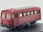 Miniatura ferroviária die-cast/metálica do vagão/automotora ligeiro Schienenbus (modelo VT 95 / reboque VB 140) da Deutsche Bundesbahn (DB) na cor vermelha, fabricada na Alemanha Ocidental ("Made in Western Germany" / Märklin). Apresenta teto cinzento com ripas longitudinais, frisos prateados circundantes, emblema "DB" e numerações de classe/matrícula tampografadas na lateral, janelas panorâmicas com armação detalhada, faróis frontais/traseiros encarnados, engates ferroviários funcionais e sapata de contacto elétrico no chassi inferior. Medidas: 04 x 12 x 04 cm. Com marcas de tempo de uso.