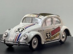 Miniatura die-cast do icónico Volkswagen VW Beetle decorado como o famoso "Herbie" ("Gross in Fahrt"), produzida em escala 1/43. Apresenta carroçaria em tom branco com as faixas azul e vermelha características, o número "53" no capot e laterais, inscrições "Herbie" e "Gross in Fahrt", teto de abrir em lona cinzenta, para-choques e pormenores cromados, jantes brancas e chassi inferior em plástico preto gravado com "VOLKSWAGEN", o logótipo do fabricante, a escala 1/43 e a indicação de fabrico em chinês/inglês. Com marcas de tempo de uso.
