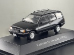 Miniatura die-cast da carrinha Chevrolet Ipanema (1991) na cor preta, pertencente à coleção "Carros Inesquecíveis do Brasil". Apresenta pormenores fiéis da carrinha clássica, incluindo barras de tejadilho, grelha frontal preta com emblema, jantes de liga leve prateadas, limpador de para-brisas traseiro, placas identificativas "Chevrolet Ipanema", base expositora gravada e caixa acrílica de proteção. Medidas: 04 x 09 x 04 cm. Com marcas de tempo de uso.