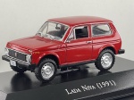 Miniatura die-cast do SUV Lada Niva (1991) na cor vermelha, pertencente à coleção "Carros Inesquecíveis do Brasil". Apresenta detalhes fiéis do modelo 4x4 soviético, incluindo grelha frontal preta com faróis circulares embutidos e piscas superiores, para-choques pretos, jantes de aço prateadas com pneus todo-o-terreno, inscrição "NIVA 1600" na tampa traseira, base expositora gravada e caixa acrílica de proteção. Medidas: 04 x 07 x 04 cm. Com marcas de tempo de uso.