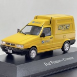 Miniatura die-cast da carrinha/furgão de transporte comercial Fiat Fiorino ao serviço dos Correios do Brasil. Apresenta cor amarela característica dos veículos do serviço de entregas. Caracteriza-se pelos logótipos oficiais "CORREIOS" e "SEDEX - MANDOU, CHEGOU.", para-choques e espelhos em plástico preto, matriculas identificativas "FIAT FIORINO", adesivo traseiro "Como estou dirigindo?", detalhes do endereço web oficial da empresa e base expositora rígida com a gravação "FIAT FIORINO  Correios" acompanhada de caixa acrílica de proteção.   Tamanho: 4 cm (altura)  8 cm (comprimento)  4 cm (largura).Com marcas de tempo de uso.