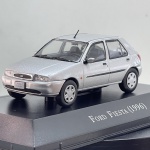 Miniatura die-cast colecionável do automóvel Ford Fiesta de 1996. Apresenta pintura na cor prateada. Caracteriza-se pela carroçaria de 5 portas, grelha oval com o emblema da Ford, faróis transparentes, limpa-para-brisas traseiro, inscrições "16V" e "Fiesta" na bagageira, antena no teto, matrículas identificativas "FORD FIESTA" e base expositora rígida com a inscrição "Ford Fiesta (1996)" acompanhada de caixa acrílica de proteção.   Tamanho: 3 cm  6 cm  3 cm.Com marcas de tempo de uso.