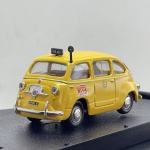 Miniatura die-cast do histórico veículo italiano Fiat 600 Multipla configurado como táxi de Milão. Apresenta pintura na cor amarela. Caracteriza-se pelo sinal luminoso "TAXI" e taxímetro exterior montados no teto, dísticos laterais "autoradio TAXI 8585 - IMOLA 50", crachá municipal nas portas, grelha e para-choques cromados, chapas de matrícula de Milão ("669483 MI" e "MI 66 9483") e base expositora rígida com caixa acrílica de proteção.Tamanho: 3 cm  7 cm  3 cm.Com marcas de tempo de uso.