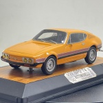 Miniatura colecionável em die-cast (metal com pormenores em plástico) na escala 1/43, fabricada pela Automodelli (by Mauro Guarnieri), referente ao icónico desportivo brasileiro Volkswagen SP2 de 1974. Apresenta pintura na cor amarela/laranja com as características faixas reflexivas duplas nas laterais em tom avermelhado e preto. Destaca-se pelo excecional rigor de acabamento, incluindo os faróis quádruplos dianteiros com lentes amareladas, emblema VW centralizado, para-choques integrados com refletores, limpadores de para-brisas detalhados, retrovisor do condutor, ranhuras de ventilação no pilar C e jantes prateadas com pneus de borracha. Encontra-se fixado sobre elegante base expositora rígida com acabamento a simular madeira e placa metálica identificativa com as inscrições "VW SP2 74 - 1/43 AUTOMODELLI by Mauro Guarnieri - BRASIL".   Medidas: 3 cm (altura)  10 cm (comprimento)  3 cm (largura).
