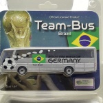 Miniatura oficial licenciada pela FIFA (fabricada por BNS GmbH / SixP.AG) referente ao autocarro da Seleção Brasileira no Mundial de Futebol de 2006 na Alemanha. Apresenta cor cinzenta/prateada predominante com grafismos de uma bola de futebol, a bandeira do Brasil e a inscrição "Team Brazil" nas laterais. Caracteriza-se pelas linhas modernas de autocarro de turismo/equipa, vidros escurecidos, logótipos oficiais do torneio "2006 FIFA World Cup Germany" e embalagem original em blister lacrado com selo de produto licenciado.   Tamanho: Aprox. 14 cm  3,5 cm  4 cm (escala 1/87).Com marcas de tempo de uso.