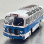 Miniatura colecionável em die-cast (metal com pormenores em plástico) na escala 1/43, referente ao autocarro clássico francês Floirat Y55. Apresenta elegante esquema de pintura tricolor em azul, branco e saia inferior clara. Destaca-se pelo apurado detalhamento de época, incluindo a grelha frontal cromada com faróis quádruplos embutidos, o emblemático logótipo "Floirat" ao centro, para-choques duplos integrados, letreiro frontal com o trajeto "ANTRAIGUES-VALS-AUBENAS", limpadores de para-brisas em miniatura, retrovisores brancos, janelas de iluminação panorâmicas no teto com acabamento escurecido, bagageiro superior vazado e placa identificativa de época "275 BA 07". Equipado com jantes e calotas centrais prateadas sobre pneus em borracha ranhurados.   Item em excelente estado geral de conservação, com pintura brilhante, estrutura totalmente íntegra e sem faltas. O chassis inferior em plástico preto apresenta a gravação em relevo original do modelo e escala: "1/43 FLOIRAT Y55"