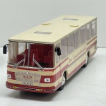 Miniatura die-cast em escala 1/43 do autocarro MAN 535 HO. Apresenta pintura bicolor em creme e vermelho com faixas laterais, inscrições "Der Langenettenbacher", grelha frontal com emblema MAN DIESEL 535, matrícula "LA-JK 122" e interior detalhado com assentos vermelhos. Com marcas de tempo de uso.