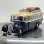 Miniatura die-cast em escala 1/43 do autocarro clássico Citroën T45. Apresenta pintura bicolor em azul e creme com guarda-lamas pretos, bagageira de tejadilho com malas simuladas, escada traseira, rodas sobresselentes duplas montadas na retaguarda, matrícula "6771-PF8" e interior detalhado. Com marcas de tempo de uso.