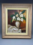 Pintura sobre tela, técnica óleo, representando natureza morta com arranjo floral composto por copos-de-leite brancos e ave-do-paraíso dispostos em vaso de cerâmica bege sobre superfície de madeira com pano claro. Fundo em tons terrosos e âmbar. Assinada no canto inferior direito: J. Silva. Apresenta moldura em madeira com acabamento envelhecido em tons dourados e prata, com filete interno na cor creme. Medidas com moldura: 58 x 52 cm. tela, quadro, obra sobre tela, composição floral, bodegón, vanitas, arranjo floral pintado, arte figurativa