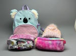 Lote composto por quatro peças: mochila infantil da marca Skip Hop, modelo Zoo, formato de koala, em tecido nas cores azul-claro, lilás e rosa, com detalhes em pelúcia creme nas orelhas, nariz em plástico preto e bolso frontal com estampa floral em relevo; nécessaire em tecido estampado com personagens Minnie Mouse e Margarida, fundo branco com detalhes coloridos; estojo em pelúcia tie-dye nas cores rosa e lilás com zíper e pingente de coração; e touca de malha infantil na cor rosê com pompom multicolorido. Itens com sinais de uso. bolsa escolar, mochilinha, porta-lápis, gorro, pompom, personagem Disney, Zoo pack, necessaire, bolsinha