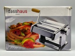 Máquina de macarrão manual, marca Dasshaus, em metal cromado, com rolos laminadores e manivela de acionamento com cabo em plástico amarelo. Acompanha grampo de fixação em metal cromado com borboleta plástica amarela para fixação em superfície. Apresenta marcas de uso e oxidação nos rolos. Acondicionada na caixa original, com desgastes na embalagem. Caixa traz inscrição 'Modelo e design italiano'. Itens acompanhados de embalagem original. cilindro para massa, laminadora de macarrão, rolo de massa, pastifício doméstico, máquina de talharim