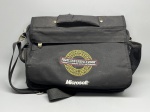 Bolsa tipo messenger em tecido sintético preto, com alça de ombro removível e ajustável com fivelas metálicas. Frente estampada com logotipo bordado da RSA Conference 2007 (February 59, Moscone Center, San Francisco) e marca Microsoft. Possui alça de mão fixada por rebites metálicos, bolso frontal com zíper, bolso lateral em tela mesh, compartimento traseiro e múltiplos organizadores internos. Verso liso com faixa passante para fixação em trolley. Item de coleção corporativa, com sinais de uso. Fabricante do item não identificado nas imagens. shoulder bag, pasta, sacola, brinde corporativo, item promocional, bag