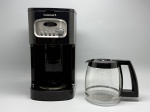 Cafeteira elétrica da marca Cuisinart, corpo em plástico na cor preta com painel frontal em aço escovado. Painel dotado de display LCD, botões de função (Clean, 1-4, HR, MIN) e seletor rotativo com funções Clock, Brew, Auto On, Prog e Auto Off. Acompanha jarra em vidro transparente com alça e tampa em plástico preto, com marcações de capacidade até 12 xícaras e logomarca Cuisinart gravada na base. Apresenta sinais de uso. Não acompanha cabo de alimentação visível nas imagens. Estado de conservação a verificar pelo arrematante. coffee maker, máquina de café, aparelho para café, filtro elétrico, percolador