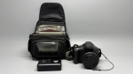 Lote composto por câmera digital Canon PowerShot SX40 HS na cor preta, com tampa de lente acoplada e alça de pulso. Acompanha carregador de bateria Canon. Bolsa para câmera da marca Lowepro, em tecido resistente nas cores preto e cinza, com alça de mão, compartimento principal com zíper, bolso frontal em tela e bolso interno em rede, além de velcro de fixação. A bolsa apresenta sinais de uso. Estado de conservação geral a verificar pelo arrematante. máquina fotográfica, câmera compacta, case fotográfico, bag para câmera, estojo