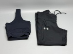 Lote composto por duas peças de vestuário esportivo feminino. Top cropped em tecido de malha canelada na cor azul-marinho, sem marcação de marca visível, alças largas e barra elástica. Legging na cor preta com logotipo Under Armour bordado em cinza na lateral da coxa, bolso lateral embutido e cordão de ajuste na cintura; etiqueta Under Armour visível na parte superior. Ambas as peças apresentam sinais de uso. Tamanho não identificado nas imagens. Estado de conservação regular. conjunto fitness, kit esportivo, roupa de treino, calça legging, top esportivo, conjunto academia, sportswear